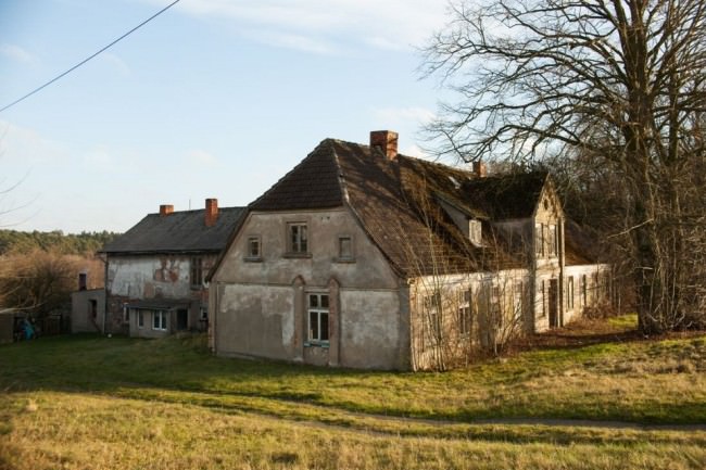 Ein großes, verfallenes Haus auf einem ländlichen Grundstück.