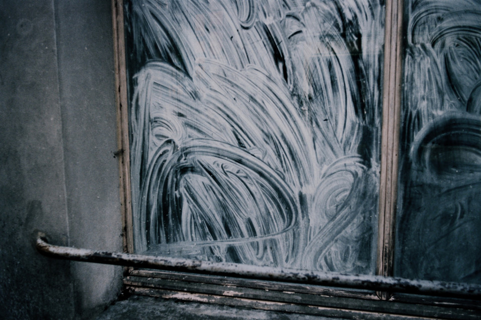 Verschmierte Seifenreste auf einer Fensterscheibe.