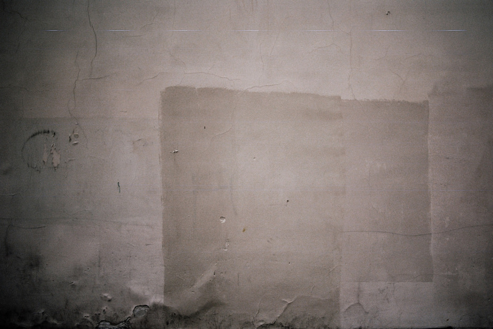 Eine weiße Wand mit Tapetenresten.