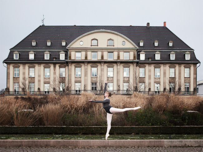Eine Ballerina tanzt vor einem Schloss.