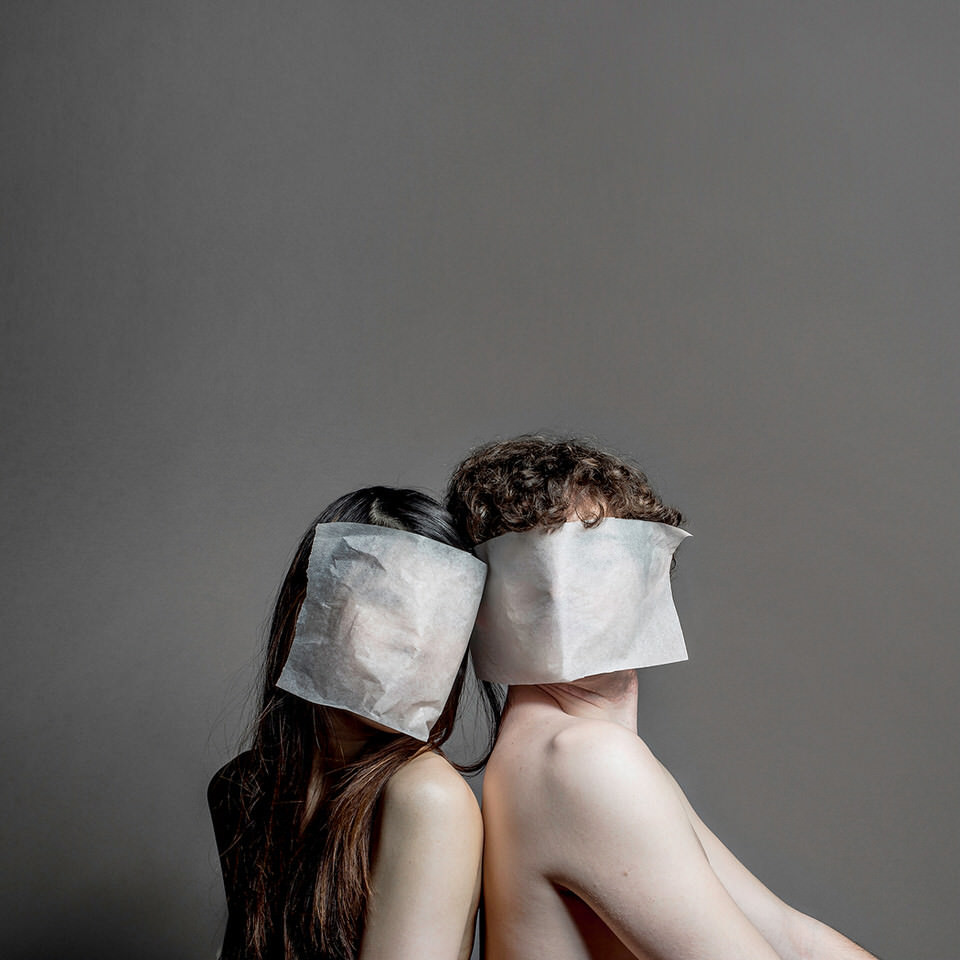 Mann und Frau mit Papier vor dem Kopf