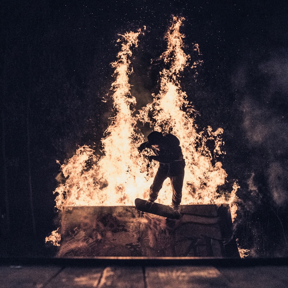 Ein Skateboarder bei der Fahrt über eine brennende Rampe.