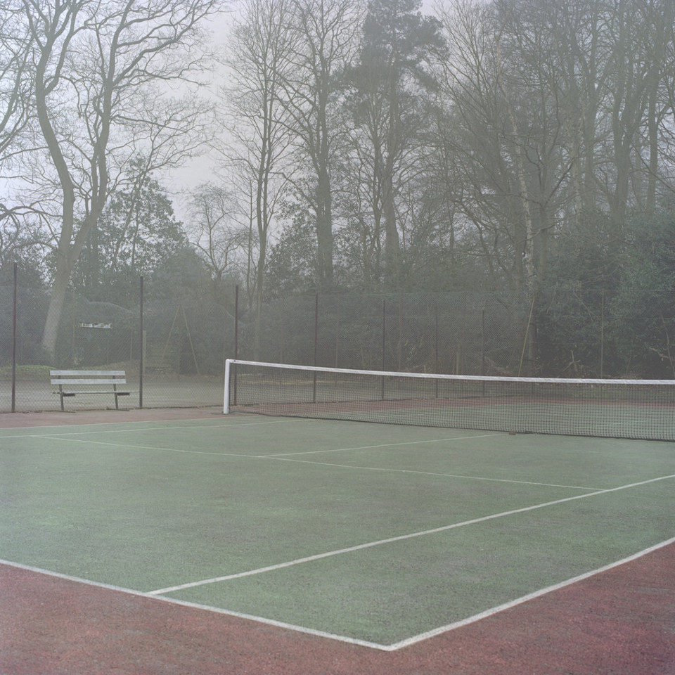Ein leeres Tennisfeld liegt im Nebel.