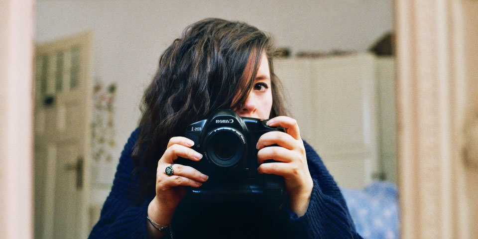 Selbstporträt einer Frau im Spiegel mit Kamera