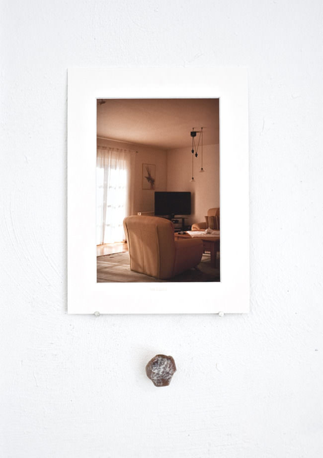 Foto eines Wohnzimmers hängt über einem Stein an der Wand.