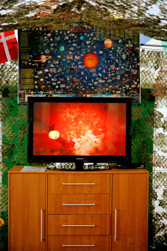Eine Planetenkarte hängt über einem Fernseher.