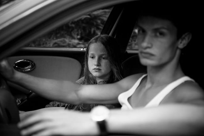 Ein Mädchen und ein älterer Junge sitzen in einem Auto.