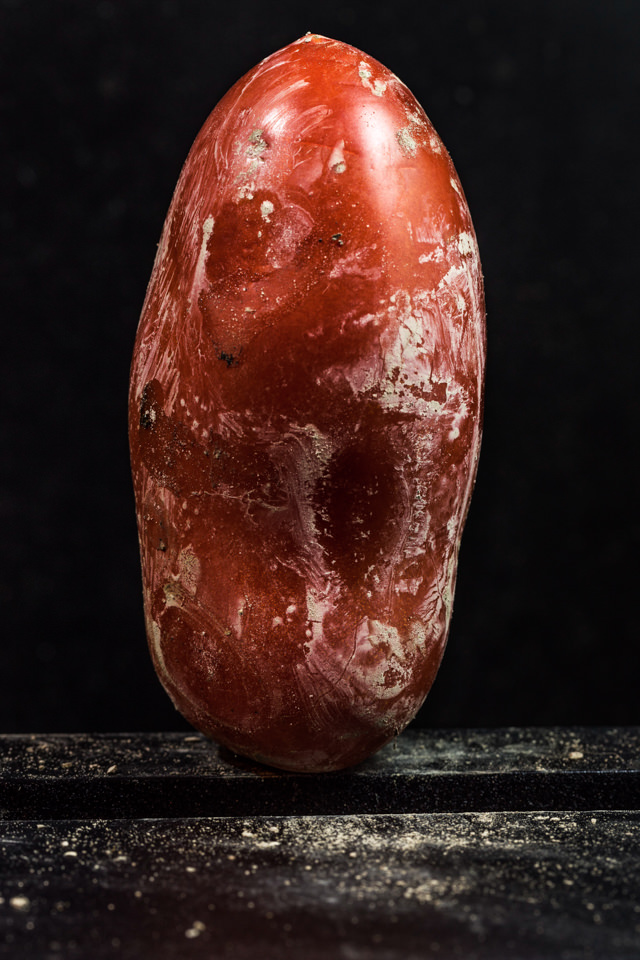 Eine Tomate vor schwarzem Hintergrund