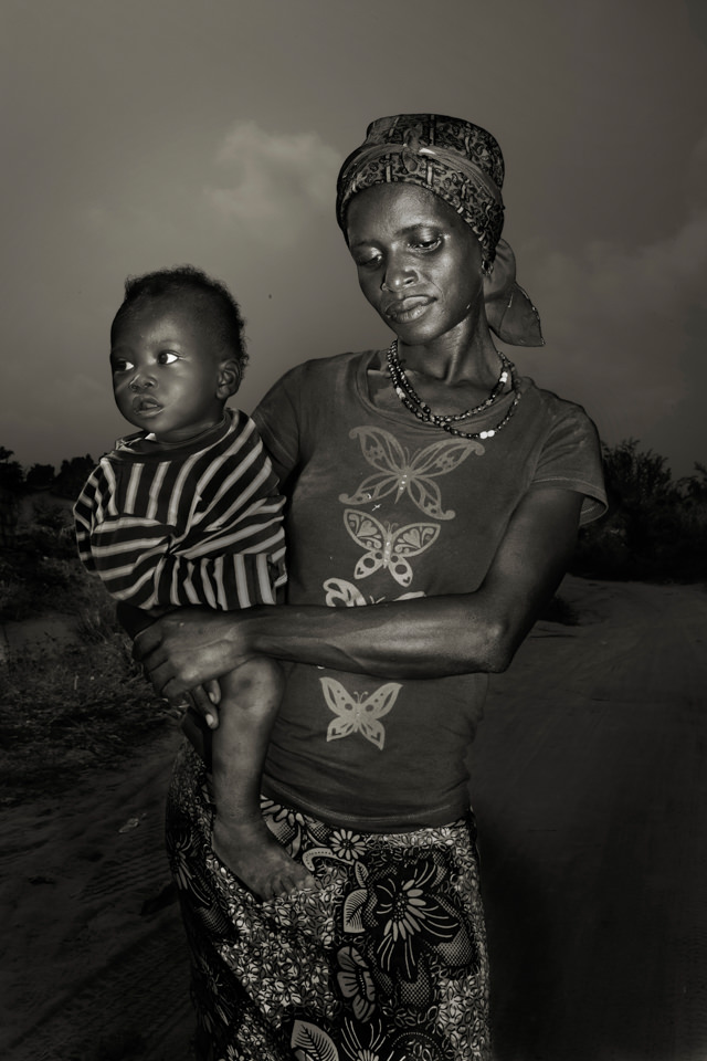 Schwarzweiß Portrait einer schwarzen Frau mit einem Kind auf dem Arm