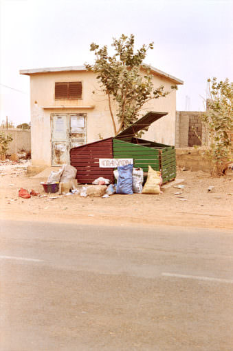 Müllcontainer mit Müllsäcken am Straßenrand.