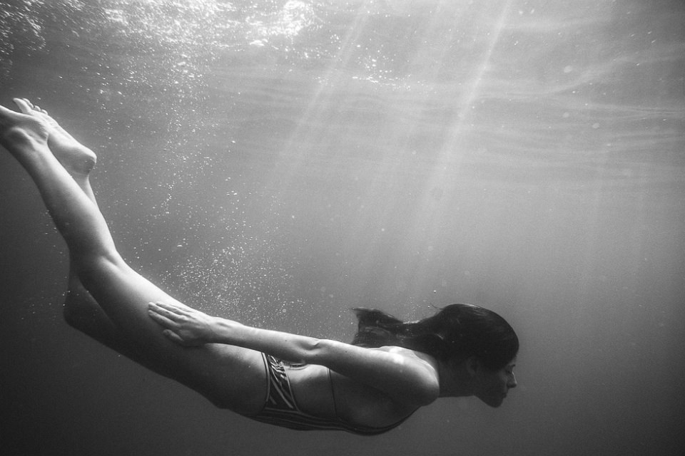 Eine tauchende Frau unter Wasser.