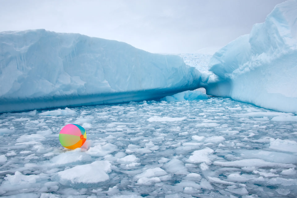 Ein bunter Wasserball schwimmt zwischen kleinen Eisschollen umher.