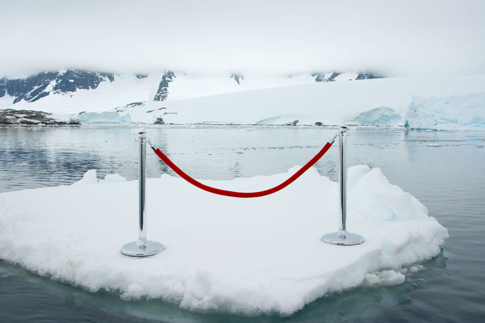 Ein rotes Absperrseil steht auf einer Eisscholle im Meer.
