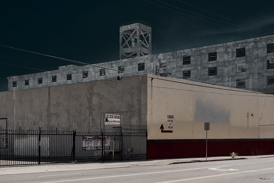 Eine alte Fabrik vor dunklem Himmel.