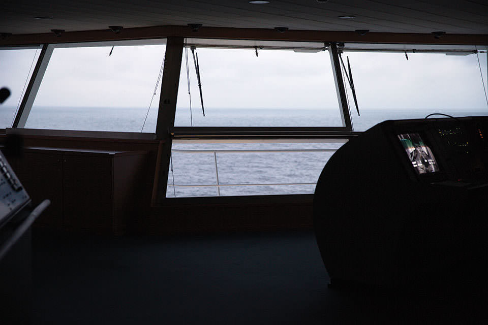 Blick auf das Meer durch ein Schiffsfenster.