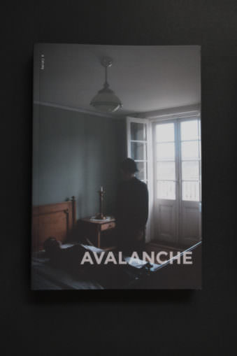 Buchcover mit den Worten Avalanche und einer Frau auf einem Bett sitzend.