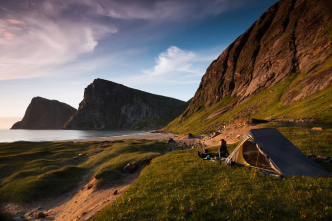Ein Zelt steht an einer einsamen Küste im Grünen.