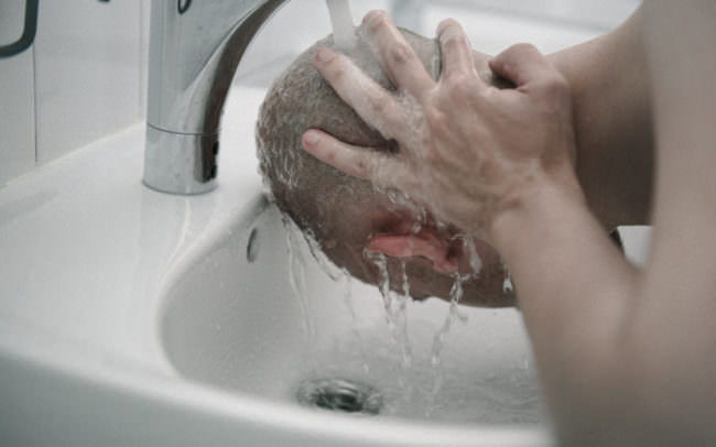 Ein Mann wäscht sich den Kopf.