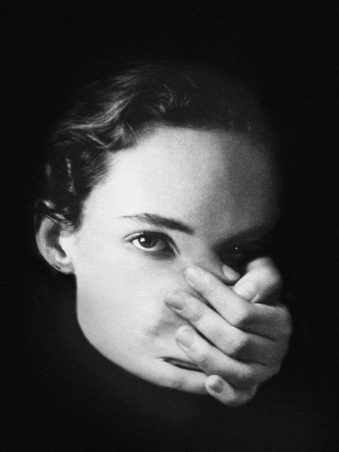 Portrait einer Frau mit Hand vor dem Mund