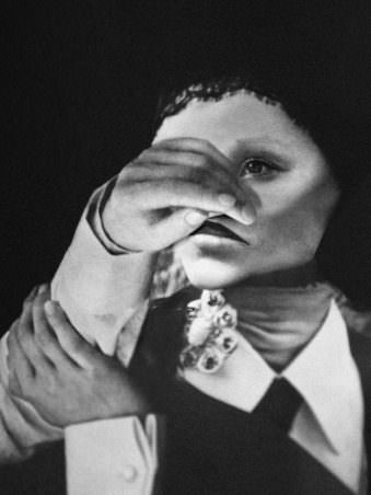 Portrait einer Frau in schwarz weiß der eine Hand vor das Gesicht gehalten wird.