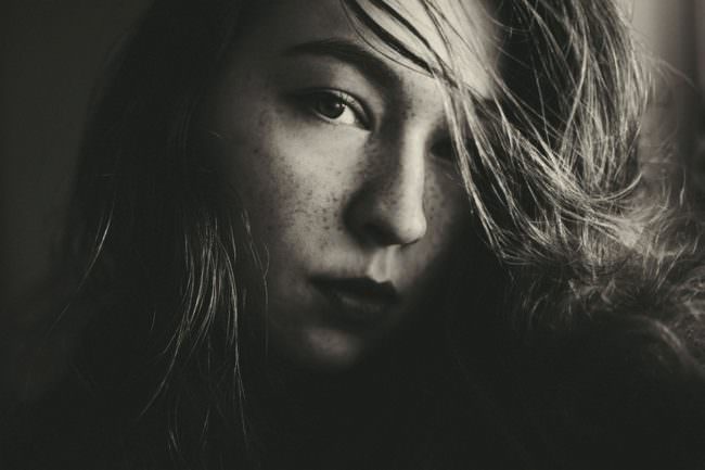 Portrait einer jungen Frau im Dunkeln.