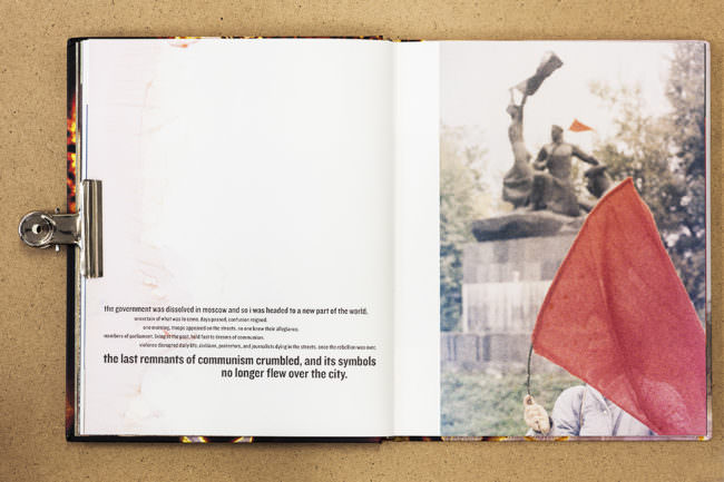 Aufgeschlagenes Buch mit Text und Fotografie einer roten Fahne vor einer Statue