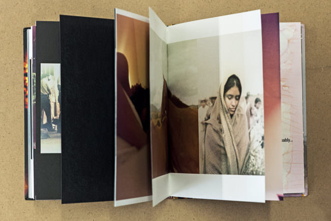 Aufgeschlagenes Buch mit Bild von einem Mädchen eingewickelt in einer Decke.