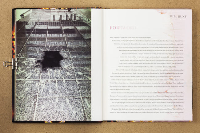 Aufgeschlagenes Buch mit Bild von einem Fleck auf Fußboden, nebenstehend Text auf der gegenüberliegenden Buchseite.