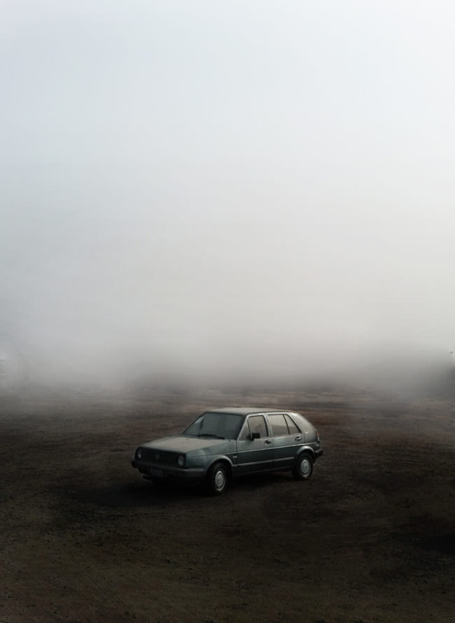 Ein Auto steht auf einem nebeligen Feld.