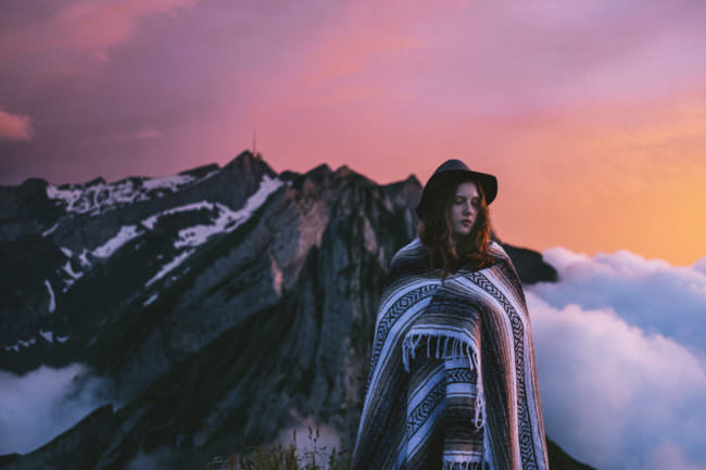 Eine junge Frau steht vor einer Bergkette