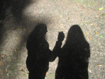 Schatten auf Waldboden von 2 Frauen.