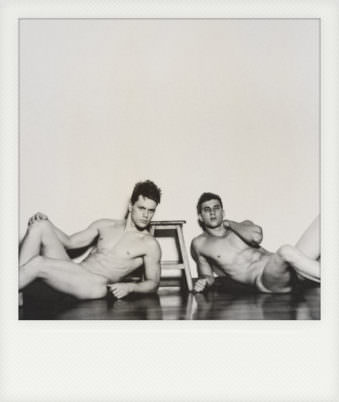 Polaroid von zwei nackten jungen Männern die auf dem Boden gestützt liegen.