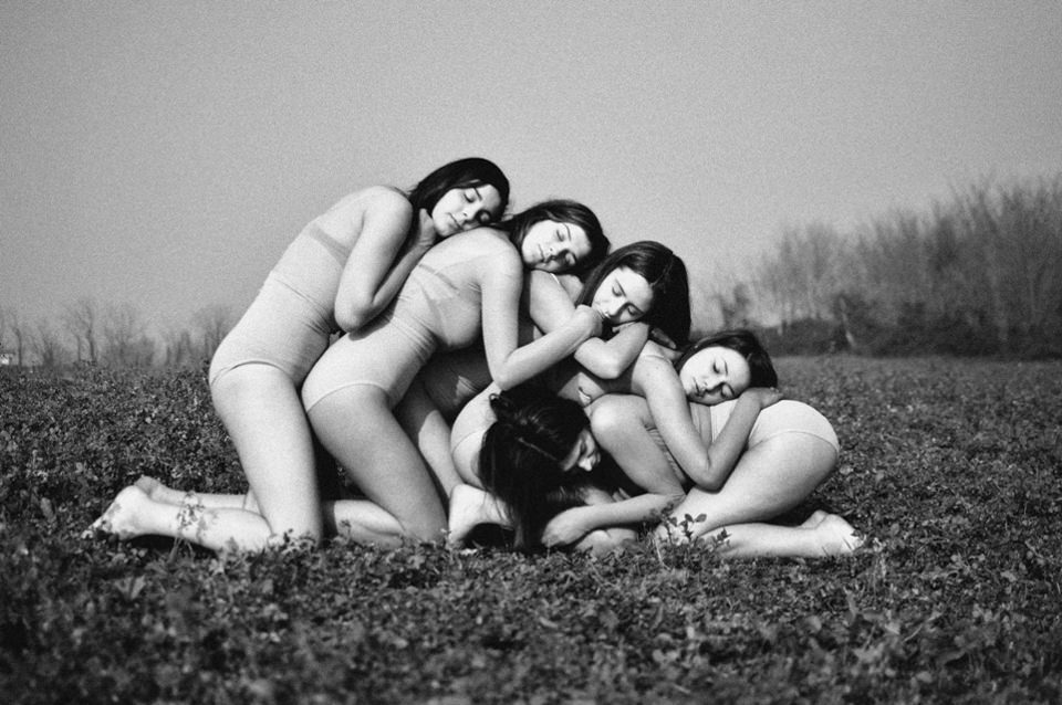 Fünf Frauen lehnen auf einer Weide aneinander.