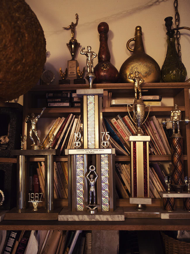 Wand mit Trophäen und Auszeichnungen in einem Bücherregal.