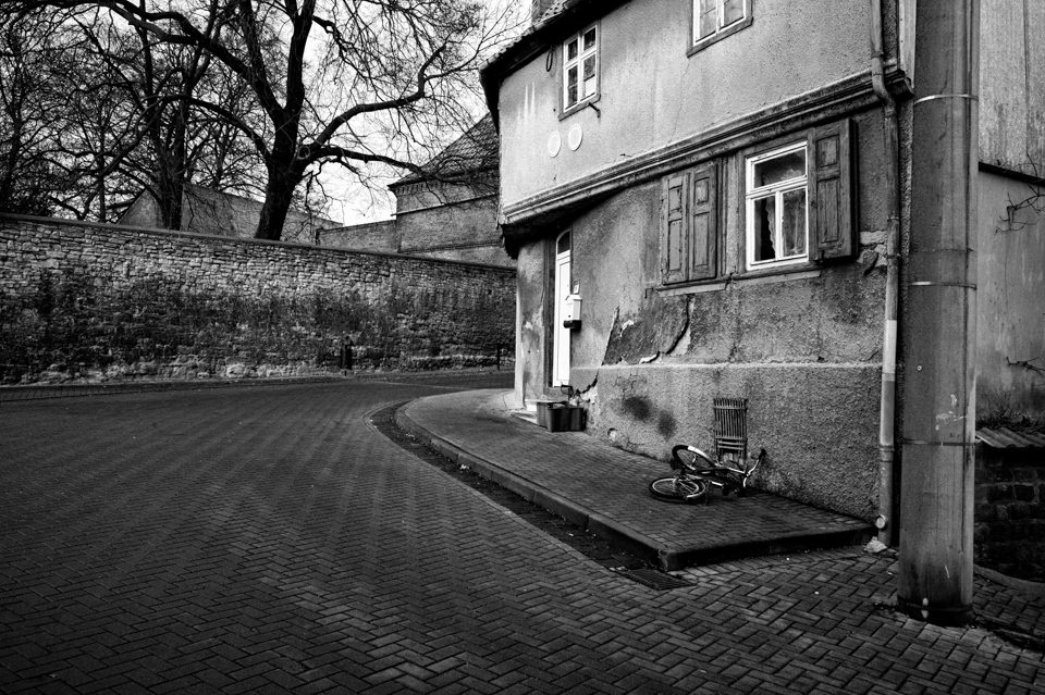 Eine Straße führt um ein altes Haus