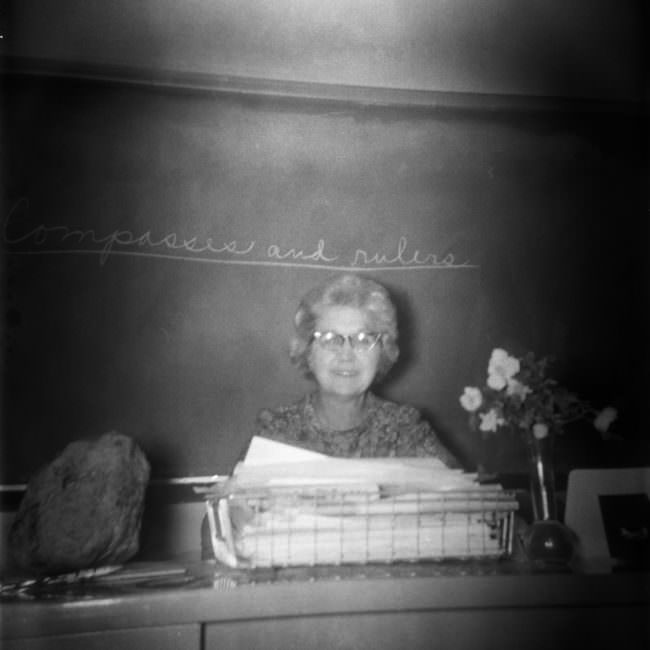 Eine Lehrerin sitzt an einem Pult