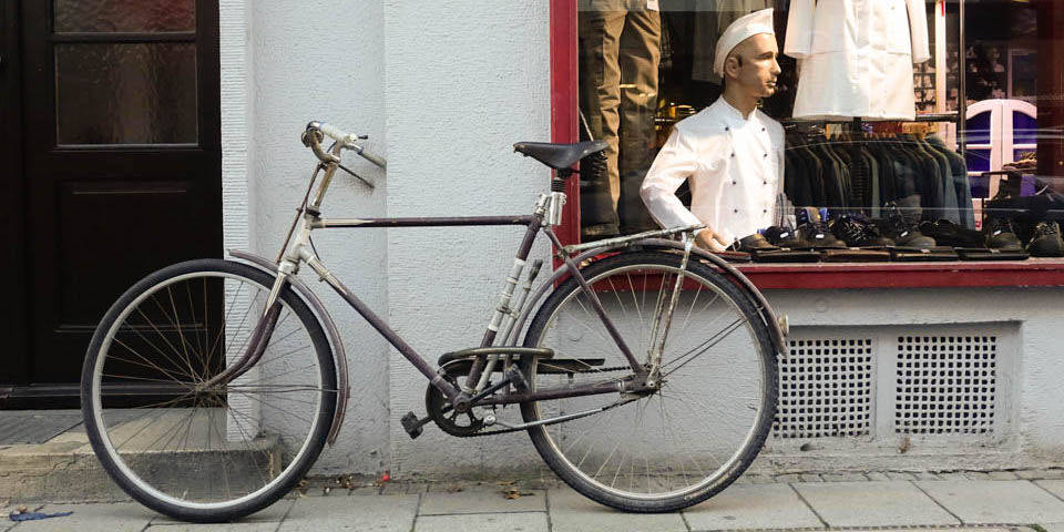 Ein Fahrrad vor lehnt an einem Fenster.