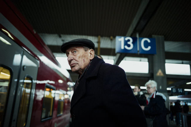 Ein älterer Mann steht an einem Bahnsteig