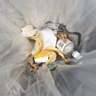 Aufnahme in einem Mülleimer mit Bananenschale und Plastikflasche.