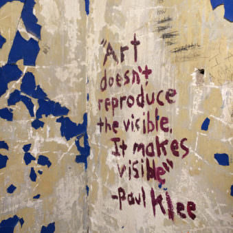 Hausecke mit abgeblätterter Farbe und einem hufgepinselten Zitat von Paul Klee.