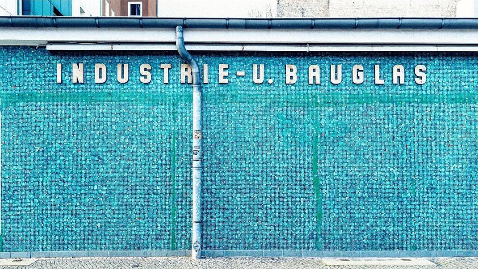 Grellblaue Wand mit Aufschrift Industrie- u. Bauglas.