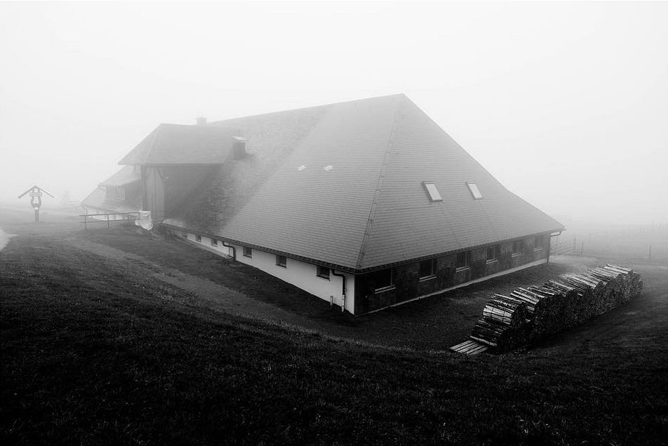 Gebäude mit hohem Satteldach im Nebel.