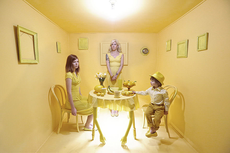 Eine Familie am Tisch in einem gelben Raum