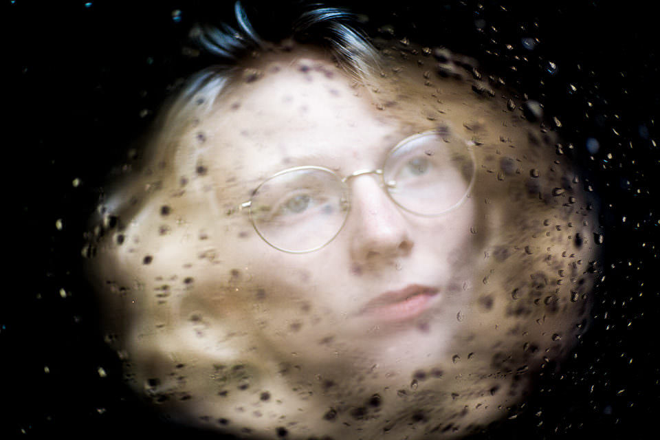 eine Frau mit sich spiegelnden Regentropfen