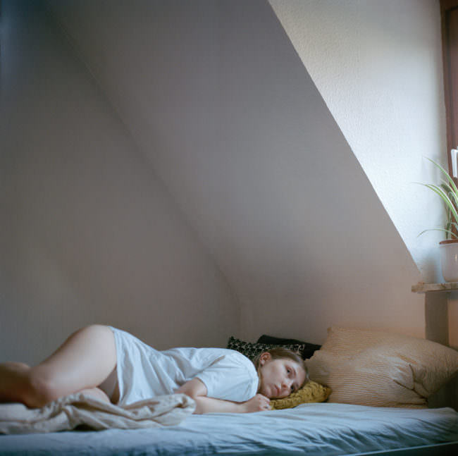 Eine junge Frau, im Bett liegend