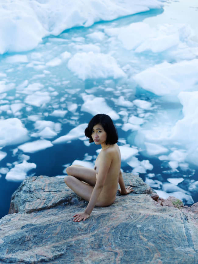 Eine Frau posiert nackt vor Eis