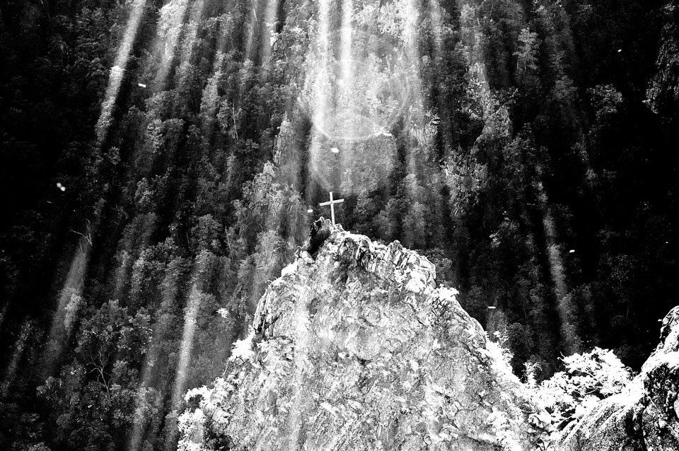 Lichter über einem Berg mit Kreuz