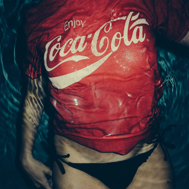 Eine Frau mit Coca-Cola-Tshirt im Wasser