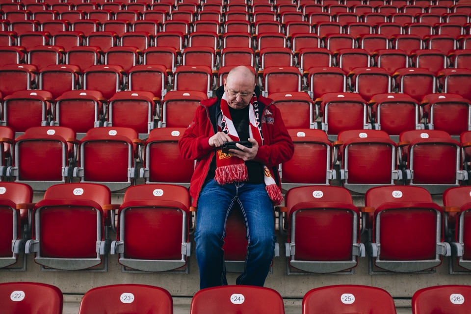 Ein Mann sitzt in einem sonst leeren Stadion