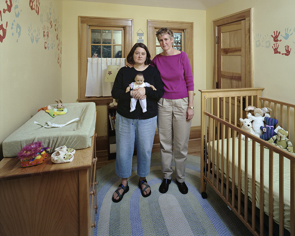 Zwei Frauen stehen in einem Kinderzimmer mit Babybett.